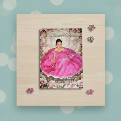 Personalized custom puzzle of a young girl in a voluminous pink princess dress sitting in a romantic rose garden setting. The puzzle is laid flat on a wooden tabletop and features the gold overlay text "My Beautiful Princess." A few loose puzzle pieces are scattered around the main, completed puzzle, emphasizing the interactive use and high-quality photo printing of the personalized picture gift.